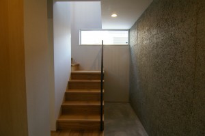 土間を広く感じさせる木毛板の壁